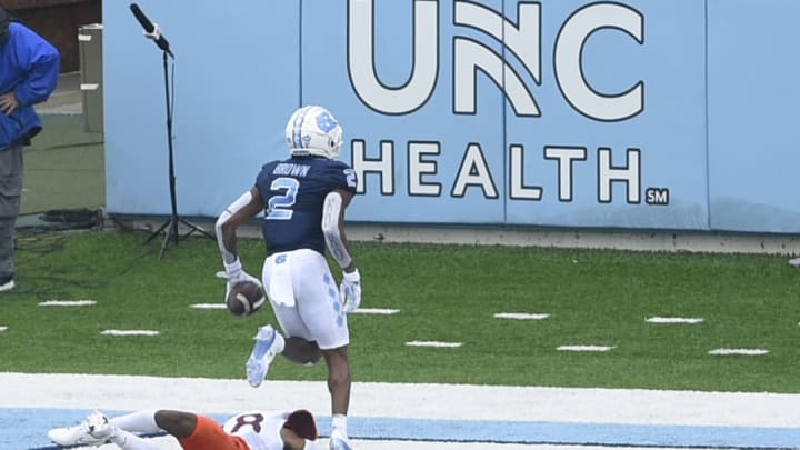 Oct 10, 2020; Chapel Hill, North Carolina, USA; North Carolina Tar Heels wide receiver Dyami Brown (2) scores as Virginia Tech Hokies defensive back Jermaine Waller (28) defends in the second quarter at Kenan Memorial Stadium. Mandatory Credit: Bob Donnan-USA TODAY Sports