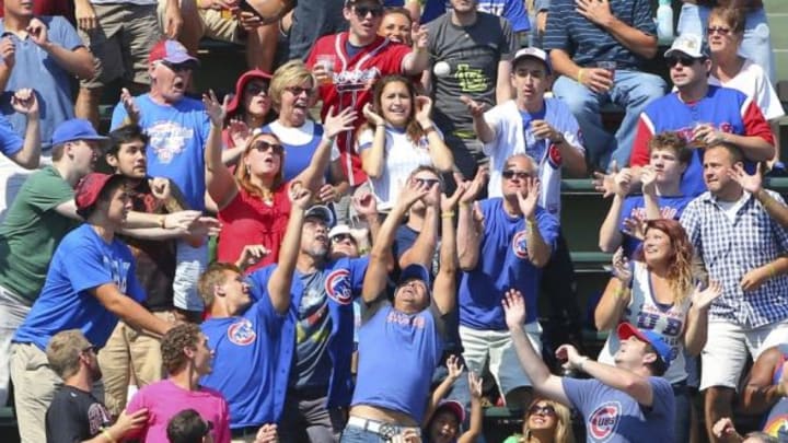 Aug 23, 2015; Chicago, IL, USA; Fans reach for the home run ball hit by Atlanta Braves catcher Ryan Lavarnway (not pictured) during the fifth inning against the Chicago Cubs at Wrigley Field. Mandatory Credit: Dennis Wierzbicki-USA TODAY Sports