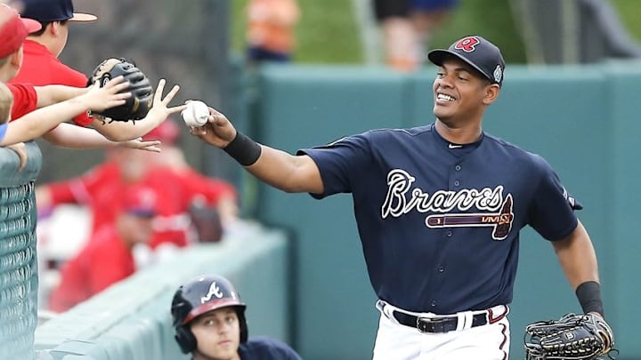 Mar 24, 2016; Lake Buena Vista, FL, USA; Atlanta Braves outfielder Hector Olivera (28) gives the ball to a fan after making an inning ending running catch during the third inning of a spring training baseball game against the Philadelphia Phillies at Champion Stadium. Mandatory Credit: Reinhold Matay-USA TODAY Sports