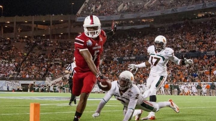 Dec 28, 2013; Orlando, FL, USA; Louisville Cardinals quarterback Teddy Bridgewater (5) rushes into the end zone for a touchdown during the second half of the Russell Athletic Bowl against the Miami Hurricanes at Florida Citrus Bowl Stadium. Mandatory Credit: Rob Foldy-USA TODAY Sports