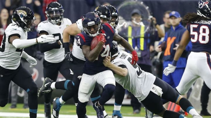 HOUSTON, TEXAS - DECEMBER 30: DeAndre Carter #14 of the Houston Texans breaks the tackle attempt by Logan Cooke #9 of the Jacksonville Jaguars as he returns a punt during the fourth quarter at NRG Stadium on December 30, 2018 in Houston, Texas. (Photo by Bob Levey/Getty Images)