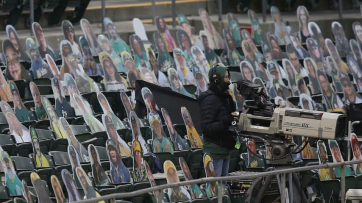 OAKLAND, CALIFORNIA - AUGUST 05: A camera operator works among the cardboard cutouts of fans during the game between the Oakland Athletics and the Texas Rangers at Oakland-Alameda County Coliseum on August 05, 2020 in Oakland, California. (Photo by Lachlan Cunningham/Getty Images)