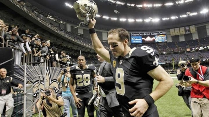 Dec 29, 2013; New Orleans, LA, USA; New Orleans Saints quarterback Drew Brees (9) holds his helmet up to fans as he leaves the field at the Mercedes-Benz Superdome. New Orleans defeated the Tampa Bay Buccaneers 42-17. Mandatory Credit: Crystal LoGiudice-USA TODAY Sports