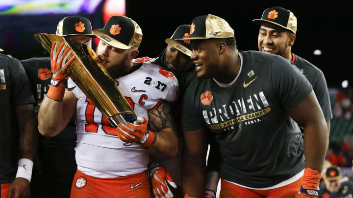 TAMPA, FL – JANUARY 09: Clemson Tigers linebacker Ben Boulware (10) licks the National Championship trophy as Clemson Tigers defensive tackle Carlos Watkins (94) watches after the 2017 College Football National Championship Game between the Clemson Tigers and Alabama Crimson Tide on January 9, 2017, at Raymond James Stadium in Tampa, FL. Clemson defeated Alabama 35-31. (Photo by Mark LoMoglio/Icon Sportswire via Getty Images)