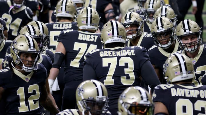 NEW ORLEANS, LOUISIANA - JANUARY 10: James Hurst #74 and Ethan Greenidge #73 of the New Orleans Saints high five their teammates ahead of the NFC Wild Card Playoff game against the Chicago Bears at Mercedes Benz Superdome on January 10, 2021 in New Orleans, Louisiana. (Photo by Chris Graythen/Getty Images)