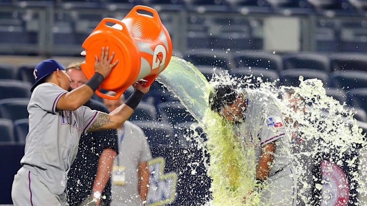 Jun 28, 2016; Bronx, NY, USA; Texas Rangers second baseman Rougned Odor (12) douses Texas Rangers shortstop Elvis Andrus (1) after defeating the New York Yankees at Yankee Stadium in a game that ended after 2:30am. Mandatory Credit: Brad Penner-USA TODAY Sports