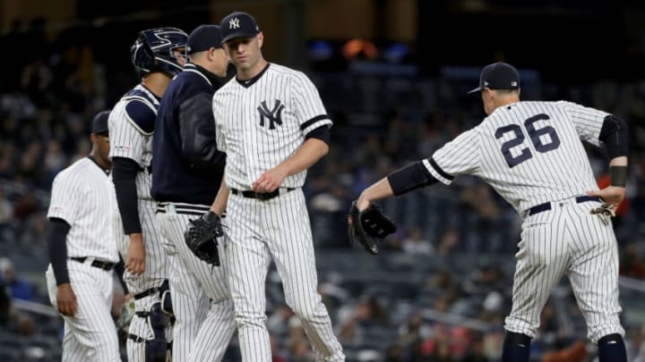 NEW YORK, NEW YORK - MAY 09: Manager Aaron Boone #17 of the New York Yankees pulls J.A. Happ #34 from the game as teammate DJ LeMahieu #26 consoles him in the sixth inning against the Seattle Mariners at Yankee Stadium on May 09, 2019 in the Bronx borough of New York City. (Photo by Elsa/Getty Images)