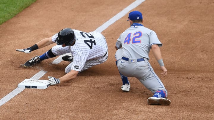 NEW YORK, NEW YORK - AUGUST 29: DJ LeMahieu #42 of the New York Yankees slides into third past J.D. Davis #42 of the New York Mets after hitting a triple during the third inning at Yankee Stadium on August 29, 2020 in the Bronx borough of New York City. All players are wearing #42 in honor of Jackie Robinson Day. The day honoring Jackie Robinson, traditionally held on April 15, was rescheduled due to the COVID-19 pandemic. (Photo by Sarah Stier/Getty Images)