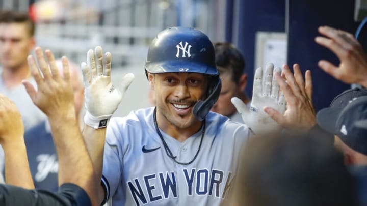 ATLANTA, GA - AUGUST 24: Giancarlo Stanton #27 of the New York Yankees celebrates with teammates after hitting a solo home run in the second inning against the Atlanta Braves at Truist Park on August 24, 2021 in Atlanta, Georgia. (Photo by Todd Kirkland/Getty Images)