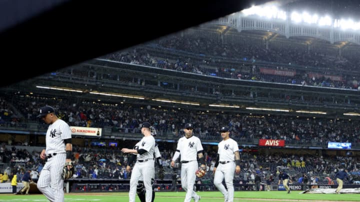 NEW YORK, NEW YORK - SEPTEMBER 25: The New York Yankees are cleared off the field as the tarp is put on the field to start the seventh inning and the game against the Boston Red Sox is in rain delay at Yankee Stadium on September 25, 2022 in the Bronx borough of New York City. (Photo by Elsa/Getty Images)