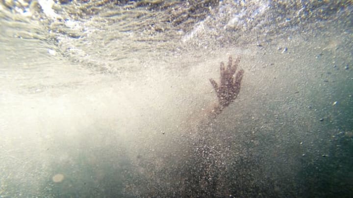 Photo of hand coming out of water