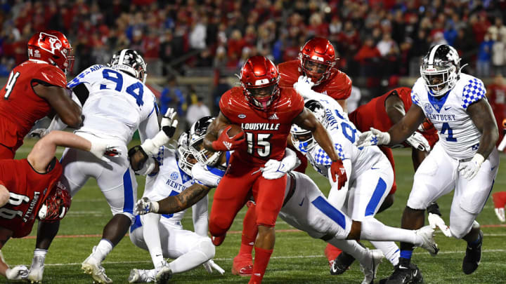 Louisville running back Jalen Mitchell (15) breaks through the Kentucky offensive line during the first half of an NCAA college football game in Louisville, Ky., Saturday, Nov. 27, 2021. (AP Photo/Timothy D. Easley)