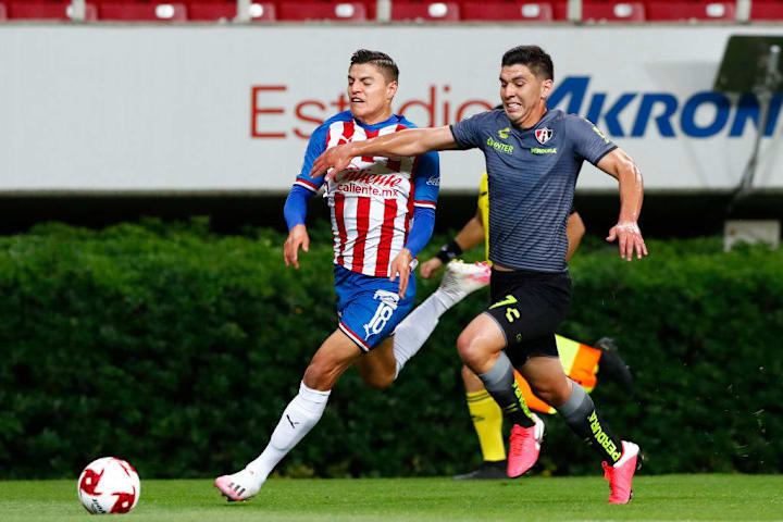 Jugadores de Chivas y Atlas pelean un balón.