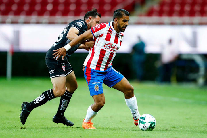 Miguel Ponce cubre el balón ante la marca de un rival.