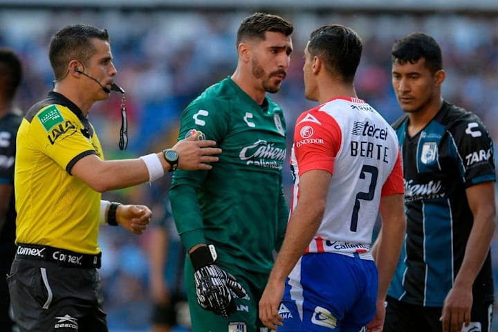 Jugadores de Querétaro y Atlético San Luis se encaran en un partido. 