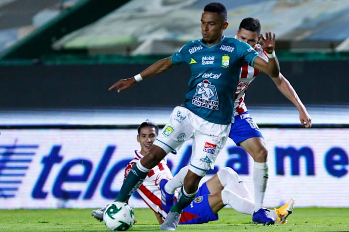 Jugador del FC León controla el balón ante la marca de dos jugadores de las Chivas del Guadalajara.
