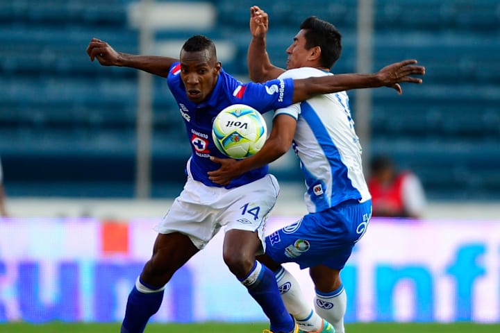 Amaranto Perea pelea el balón ante un jugador del Puebla.