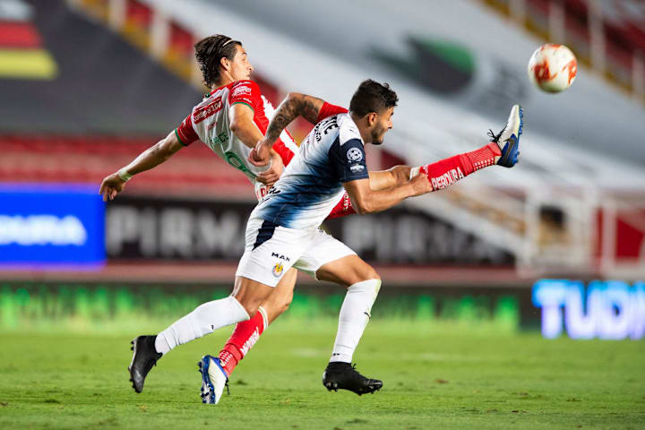 Alexis Vega pelea un balón ante un defensa rival de Necaxa.