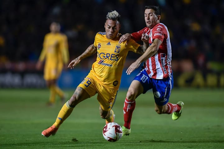 Jugadores de Tigres UANL y Atlético San Luis disputan un balón.