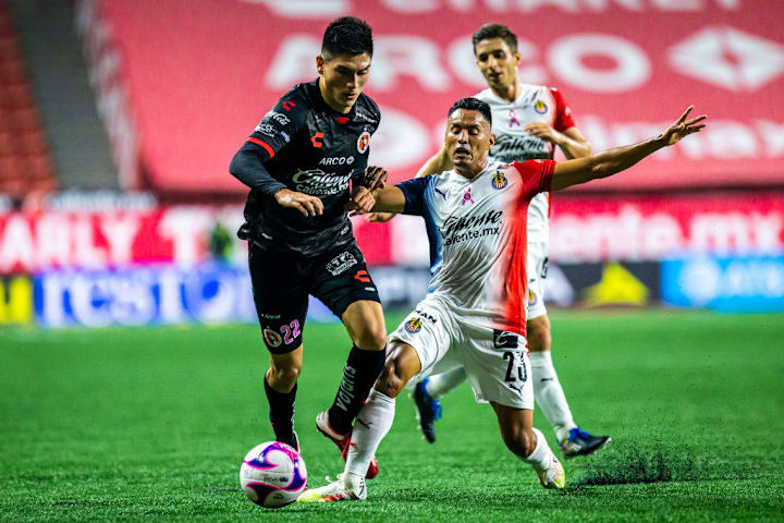 José Juan Vázquez pierde un balón ante un jugador de Xolos de Tijuana.