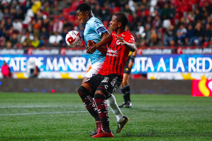 Oscar Murillo pelea el balón ante un jugador de Xolos de Tijuana.