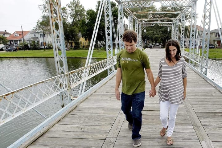 In this Monday, Sept. 19, 2011 photo, former New Orleans Saints football player Steve Gleason and his wife Michel walk on the Magnolia Bridge over Bay