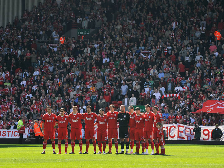 Liverpool's team players observe a minut