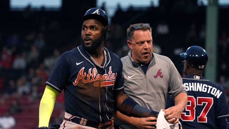 May 25, 2021; Boston, Massachusetts, USA; Atlanta Braves left fielder Marcell Ozuna (left) is assisted by a trainer after being injured against the Boston Red Sox during the third inning at Fenway Park. Mandatory Credit: David Butler II-USA TODAY Sports