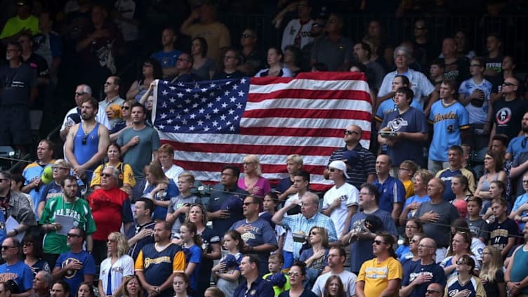 MILWAUKEE, WI - JUNE 24: Fans display an American flag during the singing of the national anthem before the game between the Milwaukee Brewers and St. Louis Cardinals at Miller Park on June 24, 2018 in Milwaukee, Wisconsin. (Photo by Dylan Buell/Getty Images)