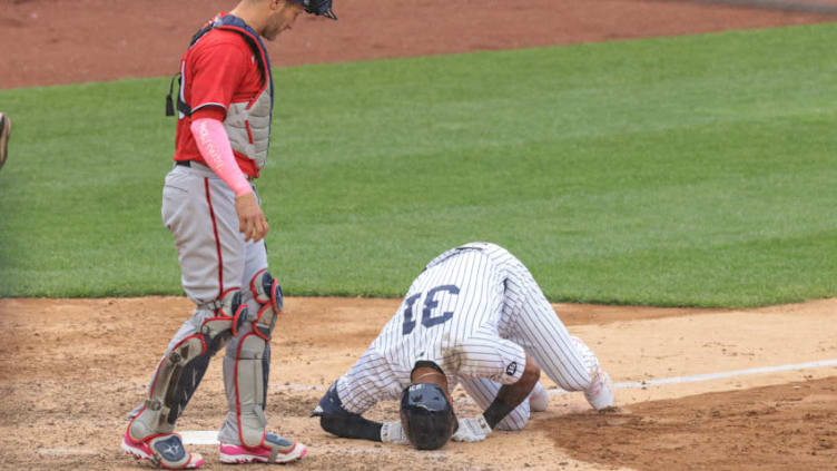 May 9, 2021; Bronx, New York, USA; New York Yankees center fielder Aaron Hicks (31) reacts after being injured during a swing as Washington Nationals catcher Yan Gomes (L) looks on during the eighth inning at Yankee Stadium. Mandatory Credit: Vincent Carchietta-USA TODAY Sports