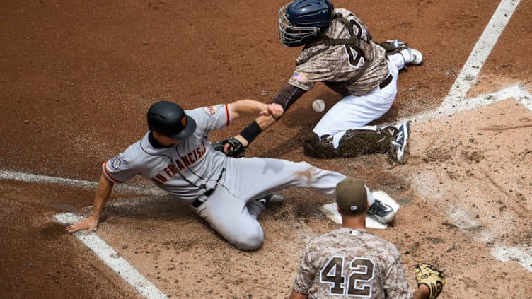 SAN DIEGO, CA - APRIL 15: Nick Hundley #5 of the San Francisco Giants, (L) scores ahead of the tag of Austin Hedges #18 of the San Diego Padres, (R) as Joey Lucchesi looks on during the second inning of a baseball game at PETCO Park on April 15, 2018 in San Diego, California. All players are wearing #42 in honor of Jackie Robinson Day. (Photo by Denis Poroy/Getty Images)