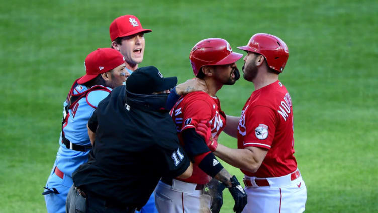 CINCINNATI, OHIO - APRIL 03: Yadier Molina #4 of the St. Louis Cardinals grabs Nick Castellanos #2 of the Cincinnati Reds after he slides safely into home base. (Photo by Emilee Chinn/Getty Images)