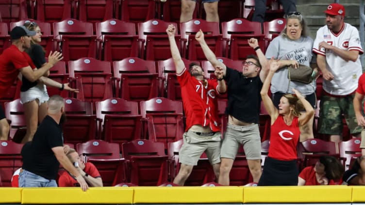 CINCINNATI, OHIO - MAY 21: Fans attempt to catch a home run hit by Jesse Winker #33 of the Cincinnati Reds. (Photo by Dylan Buell/Getty Images)