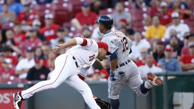 CINCINNATI, OH - AUGUST 24: Anthony Gose #12 of the Detroit Tigers evades Joey Votto #19 of the Cincinnati Reds (Photo by Joe Robbins/Getty Images)