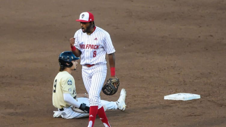 Jun 21, 2021; Omaha, Nebraska, USA; NC State Wolfpack infielder Jose Torres (8) celebrates a ninth inning double play. Mandatory Credit: Steven Branscombe-USA TODAY Sports