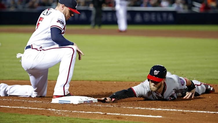 Apr 6, 2016; Atlanta, GA, USA; Washington Nationals right fielder Bryce Harper (34) dives back to first base on a pick off attempt by Atlanta Braves first baseman Freddie Freeman (5) in the fourth inning of their game at Turner Field. Mandatory Credit: Jason Getz-USA TODAY Sports