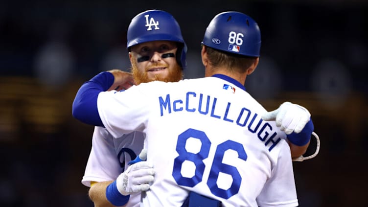 LOS ANGELES, CALIFORNIA - SEPTEMBER 20: Justin Turner #10 of the Los Angeles Dodgers hugs first base coach Clayton McCullough #86 during the fourth inning against the Arizona Diamondbacks in game two of a doubleheader at Dodger Stadium on September 20, 2022 in Los Angeles, California. (Photo by Katelyn Mulcahy/Getty Images)