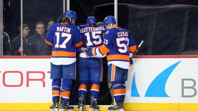 Apr 4, 2016; Brooklyn, NY, USA; New York Islanders center Casey Cizikas (53) and left wing Matt Martin (17) help right wing Cal Clutterbuck (15) off the ice after an injury during the second period against the Tampa Bay Lightning at Barclays Center. Mandatory Credit: Brad Penner-USA TODAY Sports