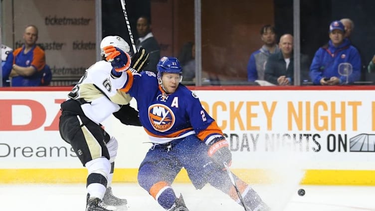 Apr 2, 2016; Brooklyn, NY, USA; New York Islanders right wing Kyle Okposo (21) and Pittsburgh Penguins defenseman Kris Letang (58) battle for the puck during the second period at Barclays Center. Mandatory Credit: Anthony Gruppuso-USA TODAY Sports