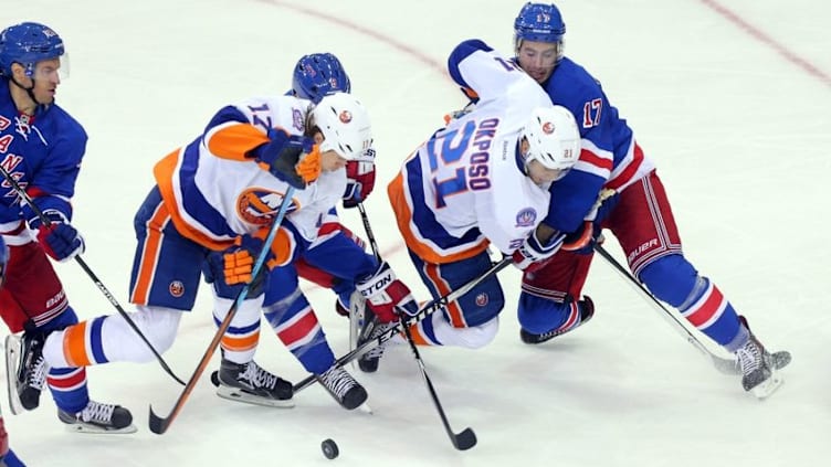 Oct 14, 2014; New York, NY, USA; New York Rangers defenseman John Moore (17), Rangers defenseman Kevin Klein (8), New York Islanders right wing Kyle Okposo (21), and Islanders left wing Matt Martin (17) battle for the puck during the second period at Madison Square Garden. Mandatory Credit: Brad Penner-USA TODAY Sports