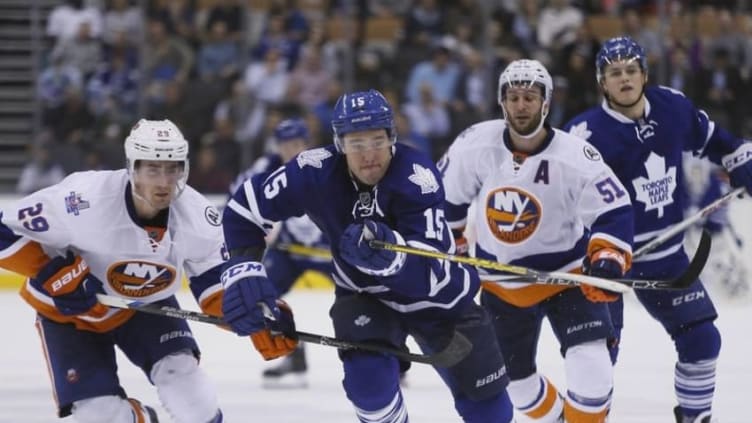 Mar 9, 2016; Toronto, Ontario, CAN; New York Islanders forward Brock Nelson (29) chases Toronto Maple Leafs forward P.A. Parenteau (15) at the Air Canada Centre. Toronto defeated New York 4-3 in an overtime shoot out. Mandatory Credit: John E. Sokolowski-USA TODAY Sports