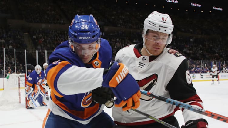 UNIONDALE, NEW YORK - MARCH 24: Lawson Crouse #67 of the Arizona Coyotes battles with Scott Mayfield #24 of the New York Islanders during the first period at NYCB Live's Nassau Coliseum on March 24, 2019 in Uniondale, New York. The Islanders shut-out the Coyotes 2-0. (Photo by Bruce Bennett/Getty Images)