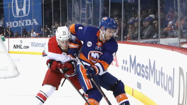 NEW YORK, NEW YORK - APRIL 28: Brock McGinn #23 of the Carolina Hurricanes hits Thomas Hickey #4 of the New York Islanders into the boards during the third period in Game Two of the Eastern Conference Second Round during the 2019 NHL Stanley Cup Playoffs at the Barclays Center on April 28, 2019 in the Brooklyn borough of New York City. The Hurricanes defeated the Islanders 2-1. (Photo by Bruce Bennett/Getty Images)