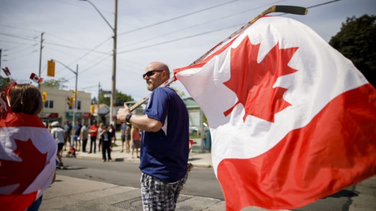 TORONTO, ON - JULY 01: A man marches with a Canadian flag on a hockey stick as Torontonian's come out to celebrate Canada Day during the East York Canada Day Parade on July 1, 2019 in Toronto, Canada. Canada Day commemmorates the formation of Canada from three distinct colonies. (Photo by Cole Burston/Getty Images)