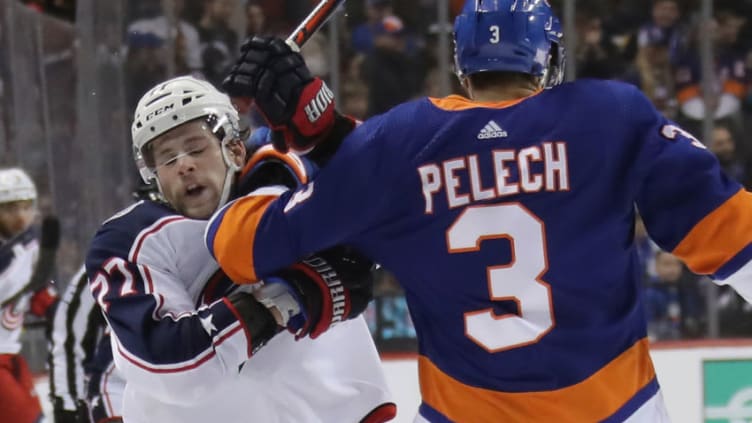 NEW YORK, NEW YORK - NOVEMBER 30: Adam Pelech #3 of the New York Islanders gets the forearm up on Josh Anderson #77 of the Columbus Blue Jackets during the third period at the Barclays Center on November 30, 2019 in the Brooklyn borough of New York City. The Islanders shut-out the Blue Jackets 2-0. (Photo by Bruce Bennett/Getty Images)