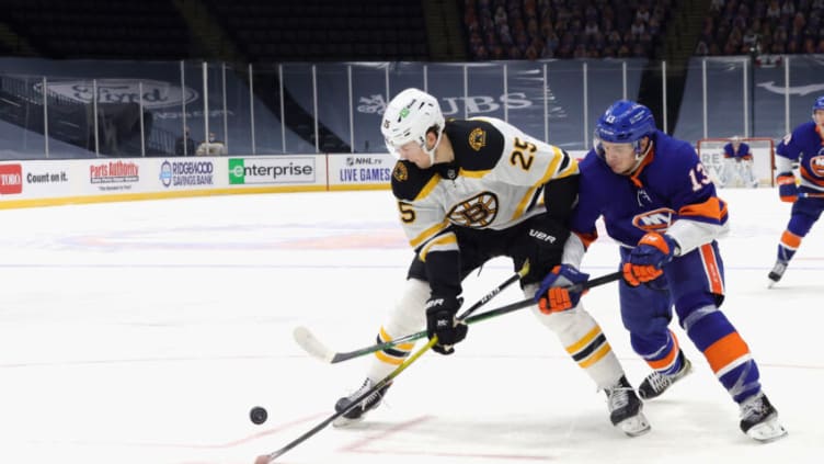 UNIONDALE, NEW YORK - JANUARY 18: Skating in his 300th NHL game, Brandon Carlo #25 of the Boston Bruins is checked by Mathew Barzal #13 of the New York Islanders during the second period at the Nassau Coliseum on January 18, 2021 in Uniondale, New York. (Photo by Bruce Bennett/Getty Images)