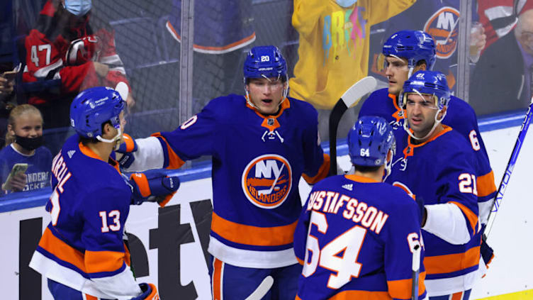 BRIDGEPORT, CONNECTICUT - OCTOBER 02: Kieffer Bellows #20 of the New York Islanders (C) celebrates his first period goal on an assist from Mathew Barzal #13 (L) against the New Jersey Devils during a preseason game at the Webster Bank Arena at Harbor Yard on October 02, 2021 in Bridgeport, Connecticut. (Photo by Bruce Bennett/Getty Images)