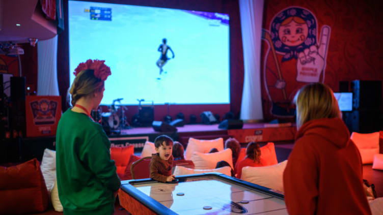 A boy plays air hockey during a televised showing of the ladies figure skating free skating event of the Pyeongchang Winter Olympics, at the Russia house in Gangneung on February 23, 2018. / AFP PHOTO / Ed JONES (Photo credit should read ED JONES/AFP via Getty Images)