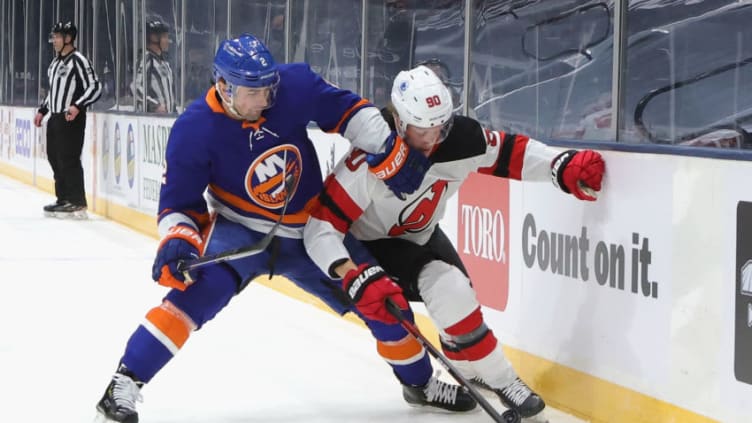 UNIONDALE, NEW YORK - JANUARY 21: Jesper Boqvist #90 of the New Jersey Devils is held back by Nick Leddy #2 of the New York Islanders during the first period at Nassau Coliseum on January 21, 2021 in Uniondale, New York. (Photo by Bruce Bennett/Getty Images)