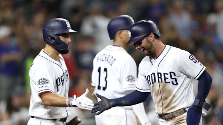 SAN DIEGO, CALIFORNIA - AUGUST 26: Greg Garcia #5 is congratulated by Eric Hosmer #30 of the San Diego Padres after scoring on a throwing error during the sixth inning of a game against the Los Angeles Dodgers at PETCO Park on August 26, 2019 in San Diego, California. (Photo by Sean M. Haffey/Getty Images)